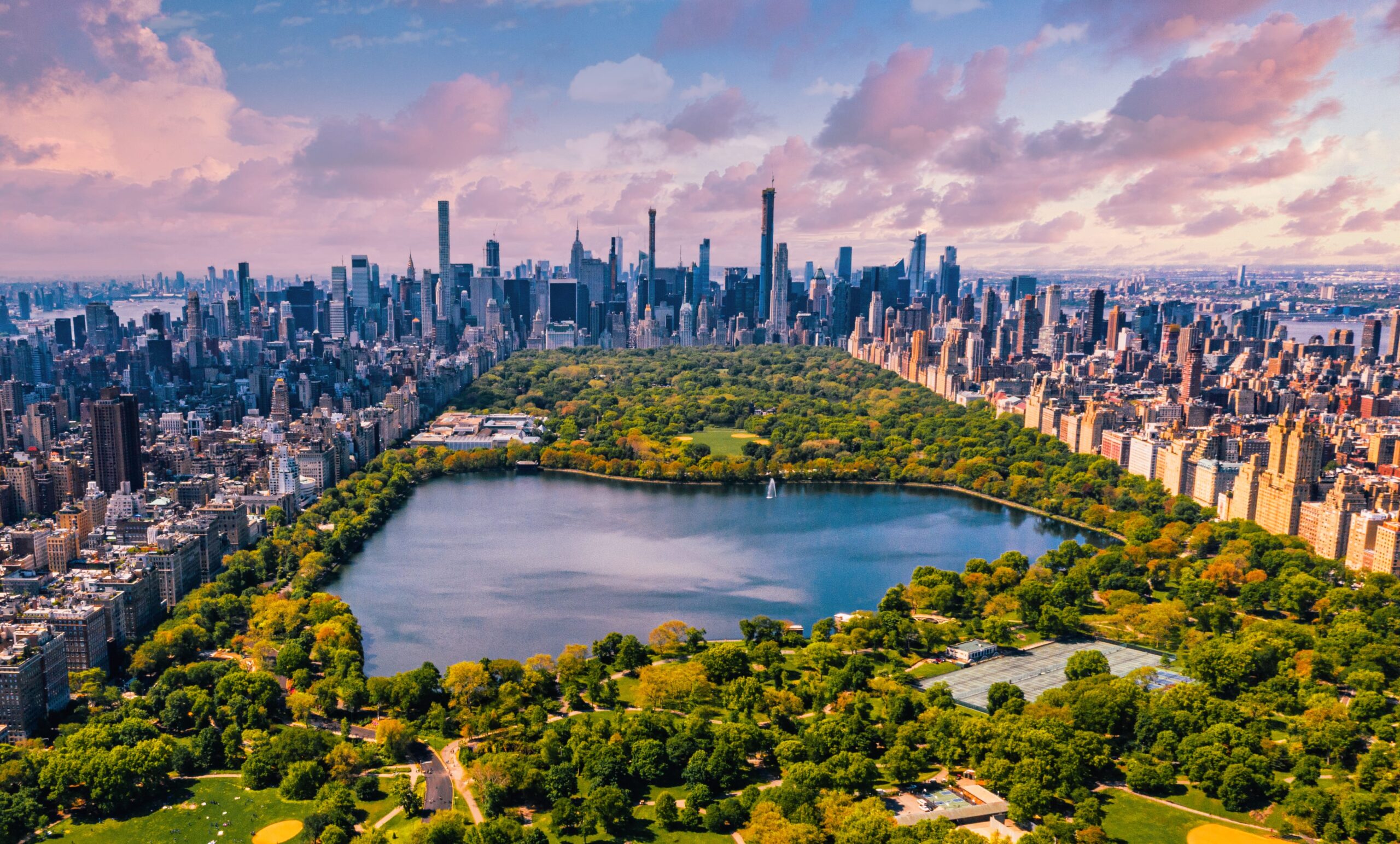 Central Park in Manhattan with surrounding skyscrapers and a peaceful pond, representing reliable vehicle shipping in busy urban areas.